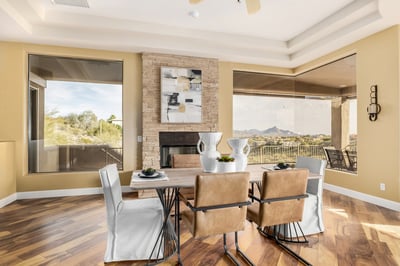 Sophisticated dining area with expansive picture windows, fireplace ambiance, and breathtaking mountain scenery. Designed for memorable meals and effortless entertaining in a luxury desert setting.
