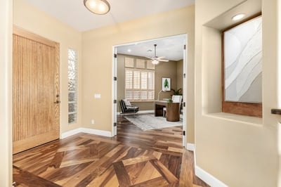 Beautiful entry hall featuring custom architectural details, warm hardwood flooring, and elegant finishes. The inviting design creates a memorable first impression upon arrival.