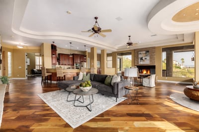 Expansive gathering space with custom ceiling architecture, fireplace centerpiece, open kitchen connection, and scenic mountain views. Perfect for hosting family and friends while enjoying indoor-outdoor living.