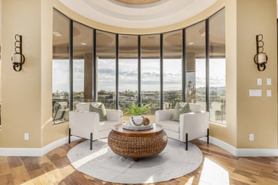 Stunning sitting area framed by floor-to-ceiling windows that bring the surrounding desert landscape indoors. The perfect space to relax while taking in the home's elevated views.