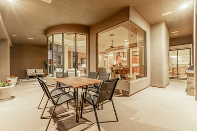 Spacious covered patio with dedicated dining space and direct access to the home's open-concept living areas. Large windows frame the surrounding scenery and elevate the indoor-outdoor lifestyle in Fountain Hills.