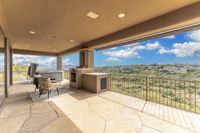 Exceptional covered patio featuring a spa, fireplace, and panoramic mountain views. Thoughtfully designed for entertaining and relaxation, this Fountain Hills outdoor oasis embodies Arizona luxury living.