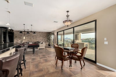 Flexible recreation room with card-playing area, wet bar access, and oversized glass doors framing scenic mountain views. Ideal for entertaining guests while enjoying the exceptional Fountain Hills landscape.