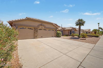A generous driveway and attached three-car garage provide ample parking, storage, and convenience. The attractive exterior design enhances the home's presence within this desirable Peoria neighborhood.