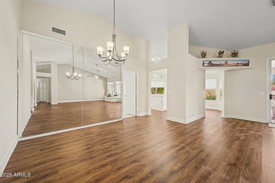 A stylish chandelier, mirrored wall accents, and rich flooring define this inviting dining area. Conveniently positioned within the open floorplan, it offers the perfect setting for gatherings and celebrations.