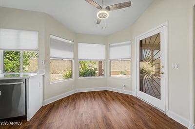 Surrounded by windows and natural light, this inviting breakfast area offers a comfortable setting for morning coffee or casual meals. The direct patio access creates seamless indoor-outdoor living and entertaining opportunities.