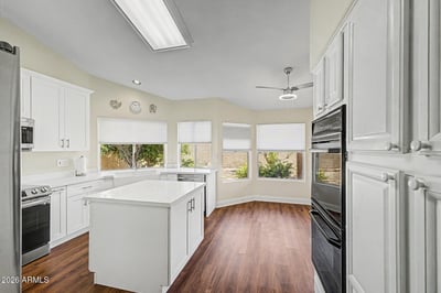 Featuring white cabinetry, stainless steel appliances, and a spacious center island, this kitchen combines style and practicality. The open layout allows easy interaction with adjacent living and dining spaces.