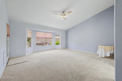 Large windows, vaulted ceilings, and neutral finishes make this spacious primary suite feel bright and welcoming. The flexible layout easily accommodates a variety of furniture arrangements and personal styles.