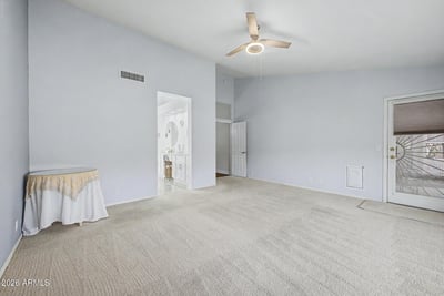 The spacious owner's suite features high ceilings, direct bathroom access, and room for additional seating or furnishings. Natural light enhances the comfortable and inviting atmosphere.