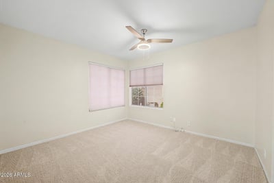 Natural light, neutral finishes, and plush carpeting create a warm and inviting atmosphere in this secondary bedroom. The spacious layout offers flexibility for guests, work-from-home needs, or additional living space.