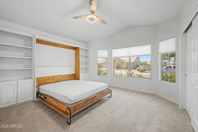 This unique room includes integrated shelving and a Murphy bed system that maximizes usable floor space. The bright layout easily transitions between bedroom, office, and multipurpose living area.