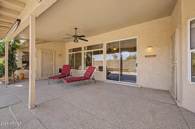 This covered patio offers abundant room for outdoor dining, entertaining, and relaxation. Ceiling fans and seamless access to the home's interior create a comfortable extension of the living space.