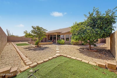 Mature trees, decorative pathways, and low-maintenance landscaping create a peaceful backyard setting. The expansive outdoor space offers privacy, functionality, and room to enjoy Arizona's beautiful weather.
