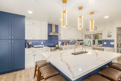 Expansive waterfall-edge island with seating anchors this upgraded kitchen featuring custom cabinetry, premium surfaces, and designer lighting throughout the Scottsdale home.