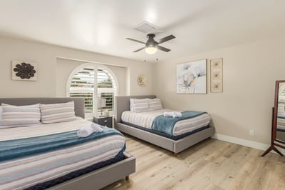 Inviting bedroom with plantation shutters, updated flooring, and flexible sleeping space. Designed to comfortably accommodate family and guests in this Scottsdale residence.