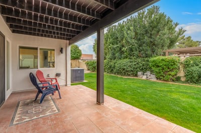 Covered patio with tile flooring, comfortable seating, and direct access to the landscaped backyard. This Scottsdale residence offers an inviting extension of the home's living space.