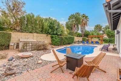 Exceptional backyard with a fire pit seating area, resort-style pool, pergola-covered dining space, and lush landscaping. This Scottsdale property offers multiple destinations for outdoor enjoyment and relaxation.