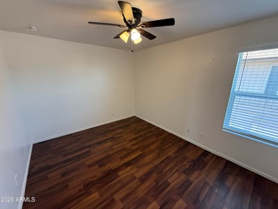 Bright and airy bedroom offering wood-look flooring, ceiling fan, and natural light. This versatile space works well as a guest room, home office, or primary sleeping area.