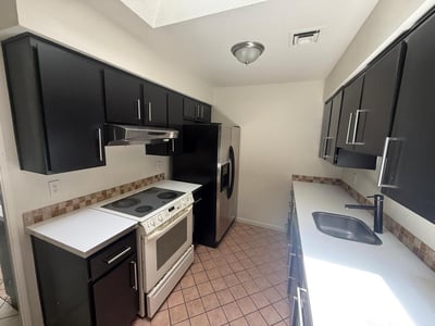 Well-designed kitchen offering plentiful cabinetry, durable surfaces, and convenient access to the main living area. A practical space that blends style, storage, and functionality.