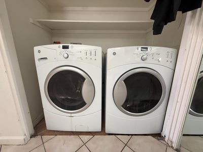 Dedicated indoor laundry space equipped with full-size washer and dryer. This