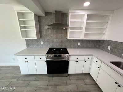 Elegant quartz surfaces, stainless steel appliances, and abundant cabinetry highlight this beautifully updated kitchen. The thoughtful design blends storage, efficiency, and contemporary style.