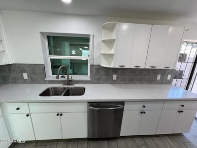 Extensive countertops, open shelving, and quality finishes make this kitchen both attractive and practical. Perfect for meal preparation, organization, and entertaining guests.