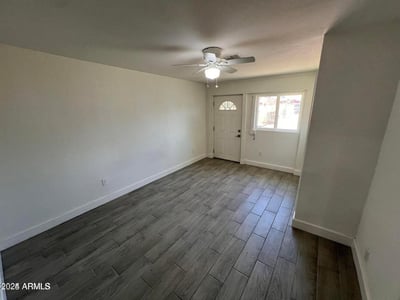 This primary bedroom offers a comfortable layout with updated finishes, ample natural light, and a ceiling fan. The room provides a relaxing private space within this beautifully remodeled home.
