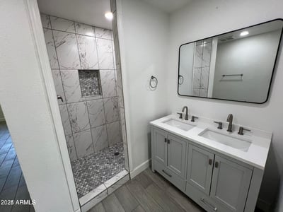 Featuring a sleek double vanity, contemporary hardware, and a stunning tiled shower, this renovated bathroom delivers both comfort and style. Elegant finishes and thoughtful updates enhance the home's overall appeal.