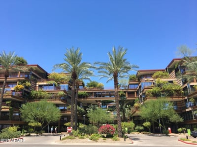 Beautiful exterior perspective highlighting the iconic architecture, landscaped courtyards, and lush greenery of Optima Camelview Village. Enjoy luxury condominium living in one of Scottsdale's most sought-after communities.