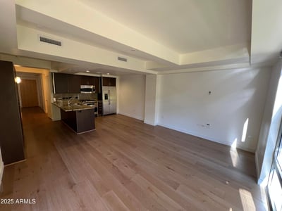Beautiful open-concept design connecting the upgraded kitchen and living room. Granite countertops, stainless steel appliances, and wood flooring create a stylish and functional environment.