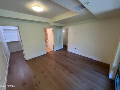 Private primary suite with warm finishes, natural light, and ample space for furnishings. The adjoining walk-in closet and ensuite bath create a comfortable retreat within the home.