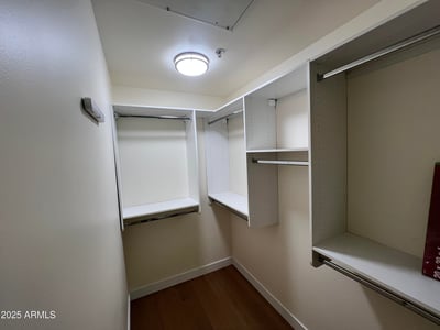 Large walk-in closet equipped with built-in shelving, hanging areas, and efficient storage solutions. Designed to keep wardrobes organized while maximizing available space.