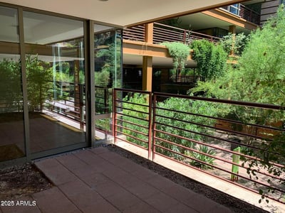 Covered patio offering private outdoor living space with views of lush landscaping and architectural details. Perfect for morning coffee, entertaining guests, or enjoying the surrounding scenery.