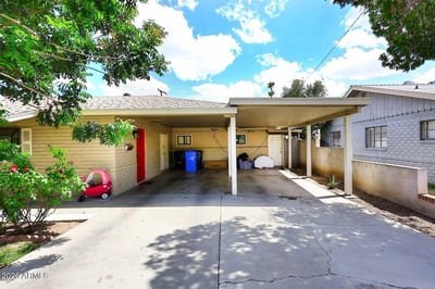 Blooming roses and established landscaping welcome visitors to this charming front entry. The covered walkway and colorful front door create a warm, inviting first impression for homeowners and guests alike.