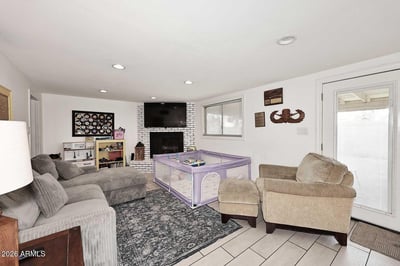 A spacious secondary living room provides flexibility for a media room, playroom, or casual gathering space. The fireplace, bright finishes, and open layout make this a standout feature of the home.