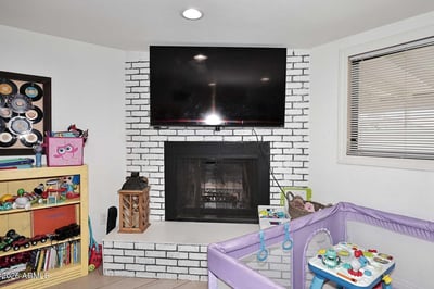 A stylish brick fireplace serves as the focal point of this comfortable family room, offering warmth, character, and entertainment potential. Recessed lighting and easy-care tile flooring complete this versatile living space.