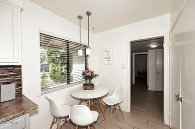 Large windows fill this breakfast nook with natural light, creating a welcoming space for dining and conversation. Positioned beside the kitchen, it provides convenience and a bright everyday gathering spot.