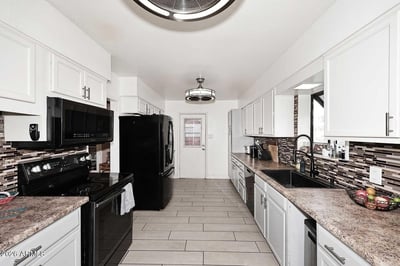 This expansive kitchen offers extensive cabinet storage, abundant prep space, and modern finishes throughout. The efficient layout supports everyday cooking while maintaining excellent flow within the home.