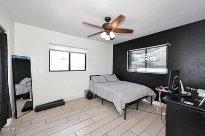 A spacious secondary bedroom with tile flooring, ceiling fan, and abundant natural light. The versatile floor plan easily accommodates guests, family members, or a home office setup.