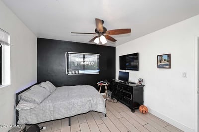 Large windows and neutral finishes create a bright atmosphere in this well-proportioned bedroom. Tile flooring and flexible space make it ideal for a variety of uses.