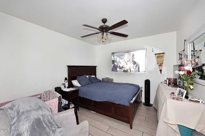 This inviting bedroom offers comfortable dimensions, natural light, and durable tile flooring. The versatile design works equally well as a guest room, office, or hobby space.