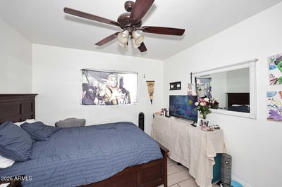 Featuring a ceiling fan, tile flooring, and generous wall space, this bedroom provides comfort and flexibility. The layout accommodates larger furnishings while maintaining an open feel.