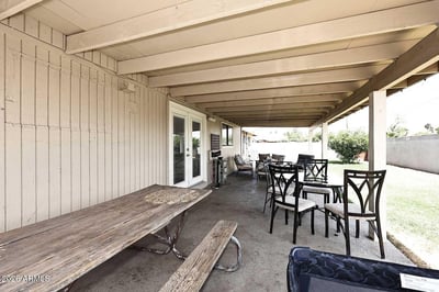 This extended covered patio creates the perfect setting for outdoor dining, gatherings, and relaxation. The spacious design offers excellent shade and seamless access to the backyard.