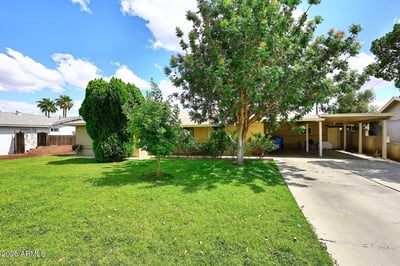 Mature trees, lush lawn, and a spacious driveway contribute to the home's welcoming curb appeal. The well-maintained front yard enhances the overall presentation of this Phoenix property.