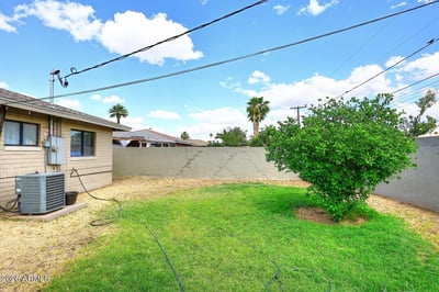 A spacious fenced backyard with mature landscaping and a large lawn creates a welcoming environment for outdoor enjoyment. The generous lot provides flexibility for recreation, pets, gardening, or future improvements.