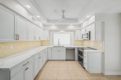 Stylish kitchen with expansive quartz work surfaces, abundant cabinetry, stainless steel appliances, recessed lighting, and a timeless neutral design perfect for entertaining and everyday cooking.