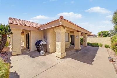 Covered patio provides shaded outdoor living surrounded by attractive desert landscaping, creating an ideal space for relaxing or entertaining year-round in Scottsdale.