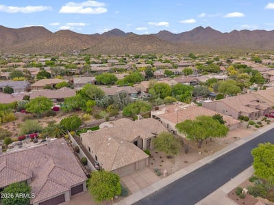 Elevated aerial showcasing the surrounding Scottsdale neighborhood, scenic mountain vistas, and the home's excellent location among beautifully maintained residences.