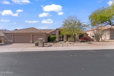 Wide front elevation displaying elegant architecture, generous driveway, and attractive desert landscaping. This beautifully updated Scottsdale residence combines modern luxury with timeless exterior design.