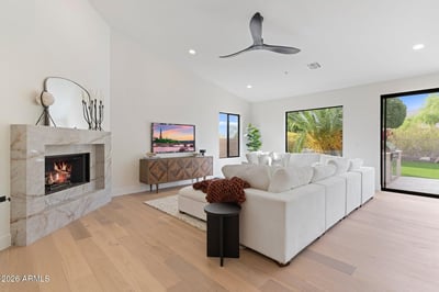 Elegant family room highlighted by a modern fireplace, soaring ceilings, oversized windows, and beautiful backyard views. Designed for comfortable living and effortless entertaining.